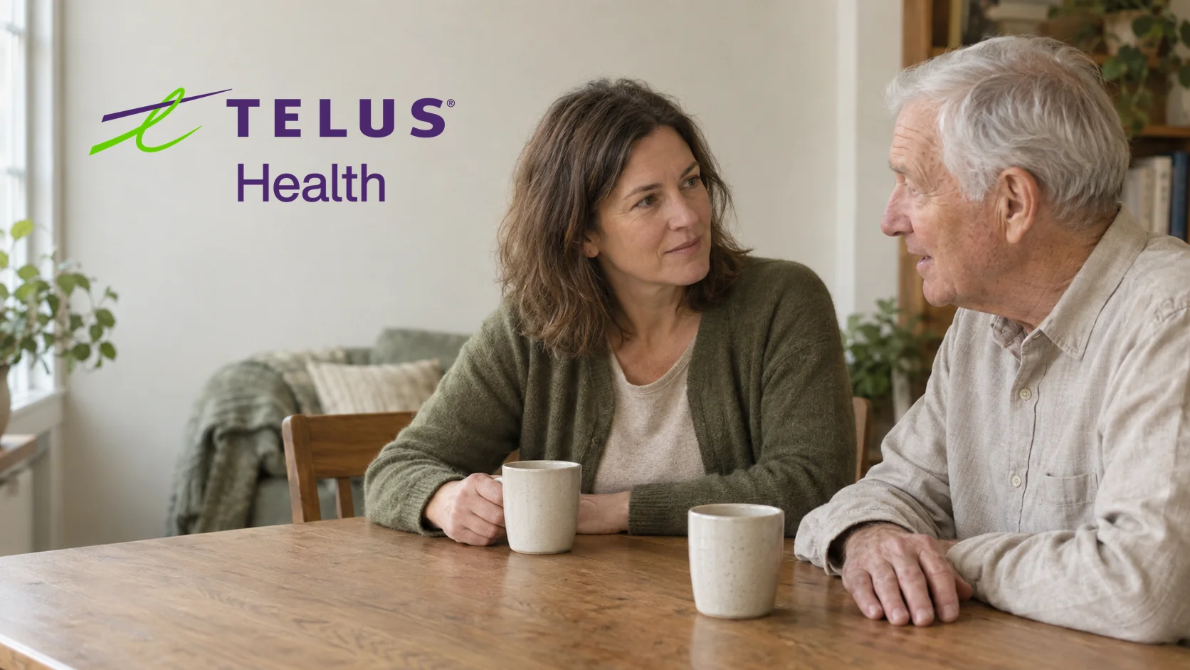 An adult daughter and her father talking over coffee at the kitchen table, with the TELUS Health logo